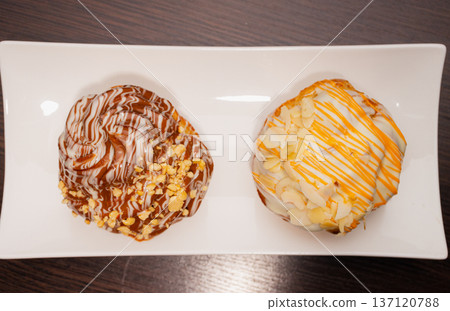 Cinnabon on a white plate and on a wooden table 137120788