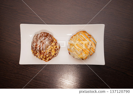 Cinnabon on a white plate and on a wooden table 137120790