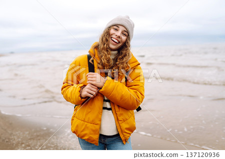Attractive woman on a windy cold beach. Travel, nature concept. 137120936