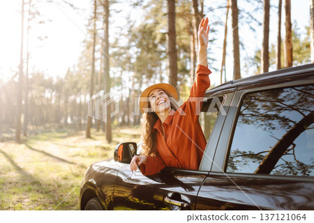 Happy woman in car window. Hair in wind. Road trip. Lifestyle, travel, tourism, nature, active life Happy woman in car window. Hair in wind. Road trip. Lifestyle, travel, tourism, nature, active life 137121064