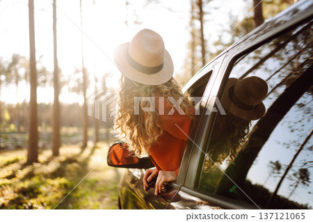 Happy woman in car window. Hair in wind. Road trip. Lifestyle, travel, tourism, nature, active life Happy woman in car window. Hair in wind. Road trip. Lifestyle, travel, tourism, nature, active life 137121065