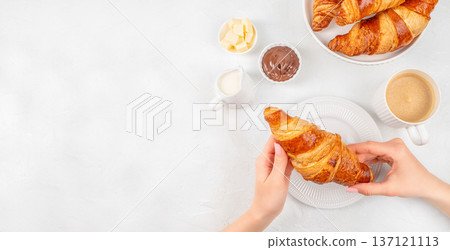Woman Holding Croissant with Chocolate Spread and Coffee in Bright Breakfast Scene. copy space 137121113