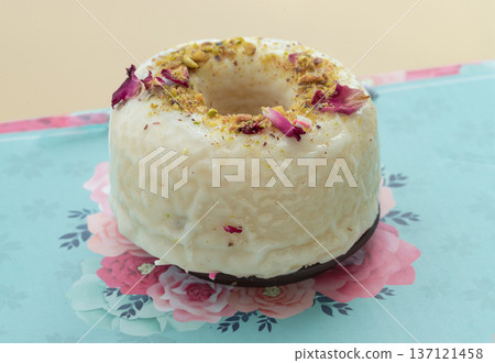 Pistachio & Rose Baked Doughnuts featuring a white glaze generously decorated with crushed pistachios and dried rose petals. Pistachio & Rose Baked Doughnuts featuring a white glaze generously decorated with crushed pistachios and dried rose petals. 137121458