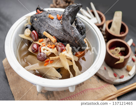 Widely celebrated in Chinese and Asian culinary traditions, the nourishing health stew pictured is known as "Black Chicken Soup" or "silkie chicken soup". 137121465
