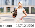 Portrait beautiful young blonde woman model smiling outdoors in urban location. Fashionable female wearing beige summer outfit and accessories, light look, modern city lifestyle, elegance, confidence 137121556