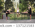 Happy mother and children doing yoga and stretching exercises together outdoors in forest park. Active family, balance and flexibility training, fitness workout in nature, summer wellness activity 137121583