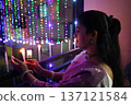 Beautiful Indian Woman Lighting Candles During Diwali Festival Celebration 137121584