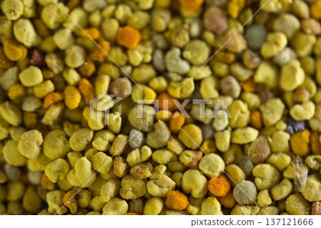 Close-up of natural bee pollen granules in vibrant yellow and orange tones, showcasing their organic texture. Close-up of natural bee pollen granules in vibrant yellow and orange tones, showcasing their organic texture. 137121666