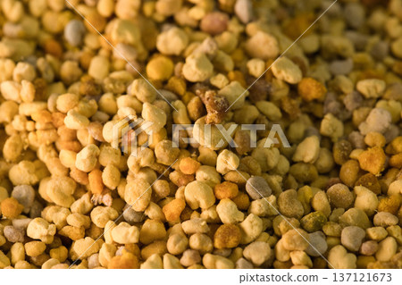 Close-up of natural bee pollen granules in vibrant yellow and orange tones, showcasing their organic texture. Close-up of natural bee pollen granules in vibrant yellow and orange tones, showcasing their organic texture. 137121673
