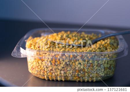 Close-up of natural bee pollen granules in vibrant yellow and orange tones, showcasing their organic texture. Close-up of natural bee pollen granules in vibrant yellow and orange tones, showcasing their organic texture. 137121681