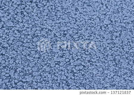 Abstract winter frost texture with delicate ice crystal patterns on a frozen surface. Natural icy background with snowflake-like details, perfect for seasonal designs, cold weather concepts 137121837