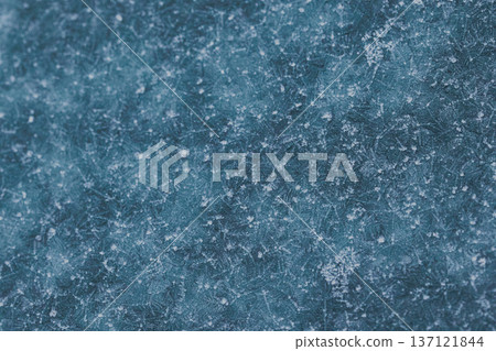 Abstract winter frost texture with delicate ice crystal patterns on a frozen surface. Natural icy background with snowflake-like details, perfect for seasonal designs, cold weather concepts 137121844