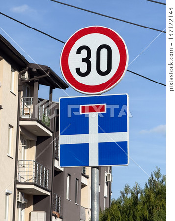 Road speed 30 sign in residential area. Urban safety, slow traffic and calm driving environment for pedestrians and local residents. Road speed 30 sign in residential area. Urban safety, slow traffic and calm driving environment for pedestrians and local residents. 137122143