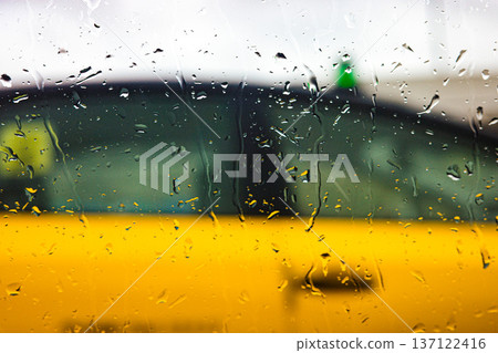 Rain drops on window glass with blurred urban background during rainy day Rain drops on window glass with blurred urban background during rainy day 137122416