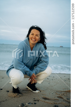 Woman Enjoying a Joyful Moment on the Beach 137122599