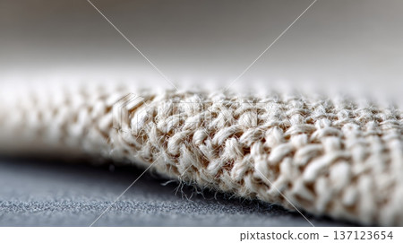 Beige macro fabric texture showing tightly woven fibers and subtle knit pattern, soft, natural surface ideal for backgrounds, textiles, home decor and product design visuals 137123654