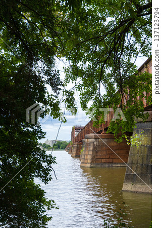 A bridge over a river with trees in the background 137123794