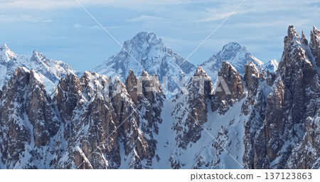 Ski mountaineer crossing a snowy ridge in the Dolomites with dramatic alpine peaks and blue sky in the background, capturing winter adventure and breathtaking mountain landscape. Ski mountaineer crossing a snowy ridge in the Dolomites with dramatic alpine peaks and blue sky in the background, capturing winter adventure and breathtaking mountain landscape. 137123863