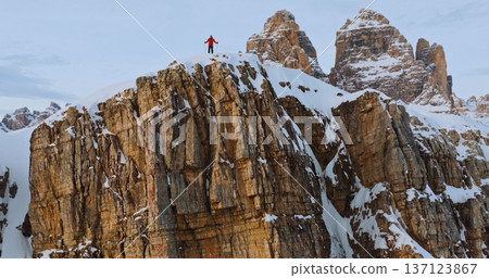 Ski mountaineer crossing a snowy ridge in the Dolomites with dramatic alpine peaks and blue sky in the background, capturing winter adventure and breathtaking mountain landscape. Ski mountaineer crossing a snowy ridge in the Dolomites with dramatic alpine peaks and blue sky in the background, capturing winter adventure and breathtaking mountain landscape. 137123867