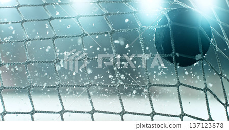 Action sports photo of a hockey puck flying into the goal net during a scoring shot, with ice particles in the air, capturing speed and intensity. Action sports photo of a hockey puck flying into the goal net during a scoring shot, with ice particles in the air, capturing speed and intensity. 137123878