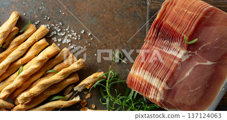 Prosciutto with bread sticks and rosemary. Prosciutto with bread sticks and rosemary. 137124063