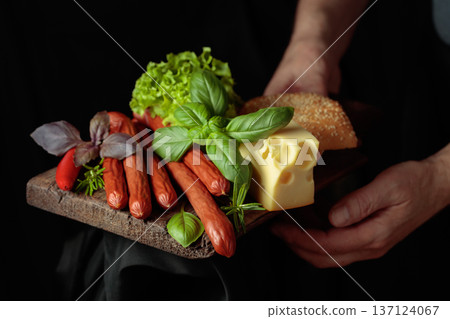 Thin smoked sausages with cheese, bread, and greens. 137124067