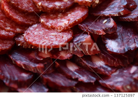 Traditional smoked salami sausage with spices.Salami sausage slices on a black chopping Board. Dark 137125897