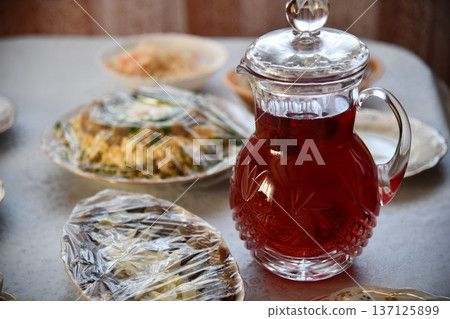 sweet compote of ripe red strawberries in a glass decanter on table 137125899