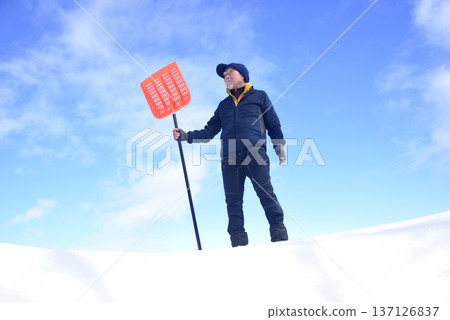 An elderly man living in a snowy country is clearing snow An elderly man living in a snowy country is clearing snow 137126837