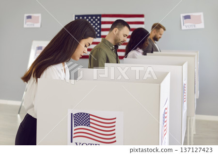 Group of people voting at ballot station during presidential elections in United States of America Group of people voting at ballot station during presidential elections in United States of America 137127423