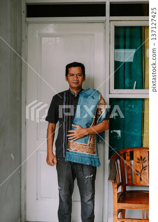 Muslim Man Holding Prayer Mat Ready for Daily Prayer 137127425