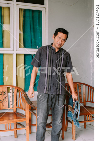 Confident Asian Man in Casual Traditional Shirt Holds Prayer Mat 137127451