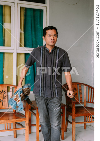 Asian Man Holding Traditional Prayer Mat Ready for Devotion Asian Man Holding Traditional Prayer Mat Ready for Devotion 137127453