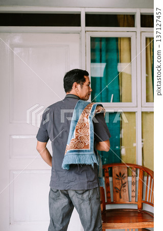 Thoughtful Man Carrying a Traditional Prayer Mat for Devotion 137127457