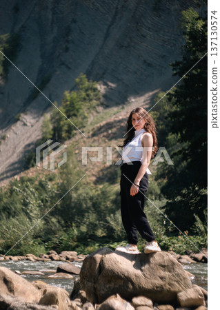 Young Woman Standing on Rock by Mountain River in Summer Nature Young Woman Standing on Rock by Mountain River in Summer Nature 137130574