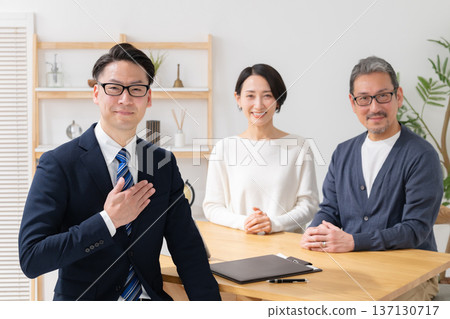 A middle-aged couple negotiating with a salesman A middle-aged couple negotiating with a salesman 137130717