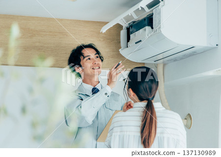 Workers inspecting air conditioners 137130989