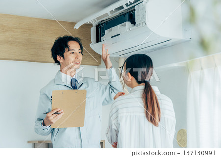 Workers inspecting air conditioners 137130991
