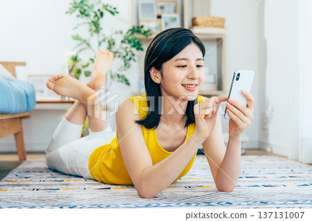 一個女人在客廳裡看著她的智能手機 137131007