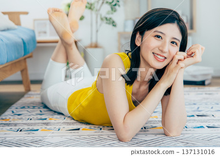 Woman lying face down on a rug 137131016