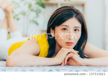 Woman lying face down on a rug Woman lying face down on a rug 137131021