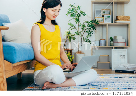 A woman watching a computer in a room A woman watching a computer in a room 137131024