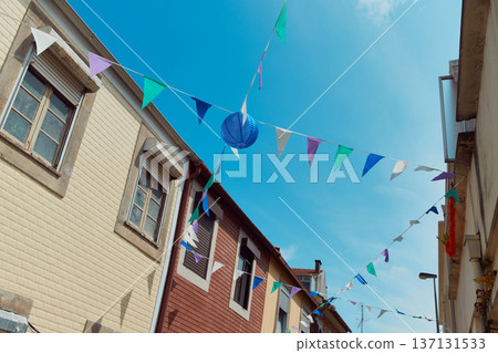 Festive bunting and lanterns decorate a narrow street for summer festival in June San Juan 137131533
