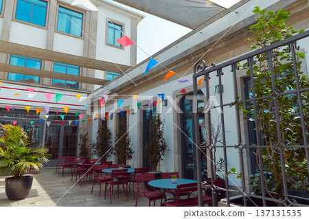 A courtyard, red chairs, and a large potted plant decorated for summer festival in June San Juan 137131535