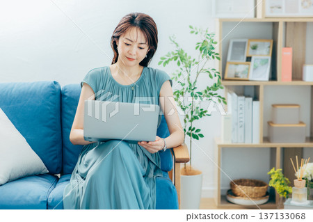 中間女性觀看個人計算機在客廳 137133068