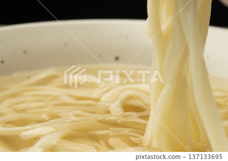 Pick up cold udon noodles with chopsticks Pick up cold udon noodles with chopsticks 137133695