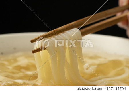 Pick up cold udon noodles with chopsticks Pick up cold udon noodles with chopsticks 137133704