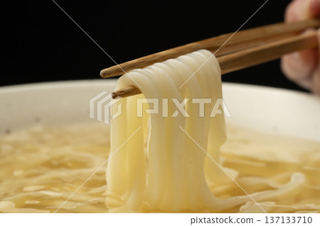 Pick up cold udon noodles with chopsticks 137133710