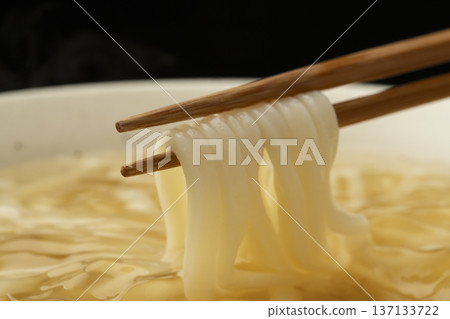 Pick up cold udon noodles with chopsticks Pick up cold udon noodles with chopsticks 137133722