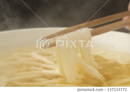 Pick up the steaming hot udon noodles with chopsticks Pick up the steaming hot udon noodles with chopsticks 137133772